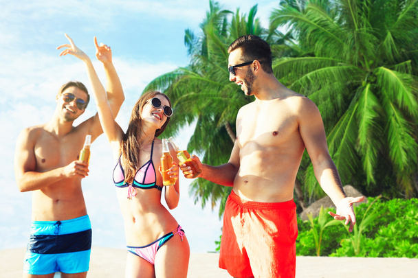 Happy friends drinking beer at beach - Φωτογραφία, εικόνα