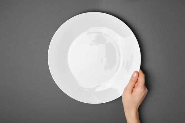 Female hand and empty plate  - Zdjęcie, obraz