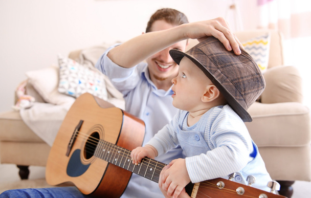 Vater spielt dem Sohn Gitarre - Foto, Bild