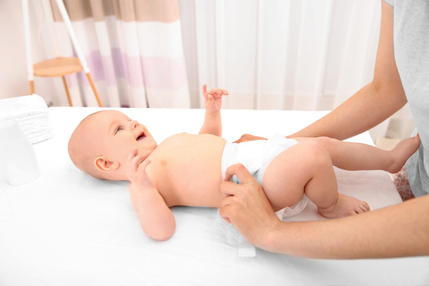 Mother changing diaper to little baby - Photo, image