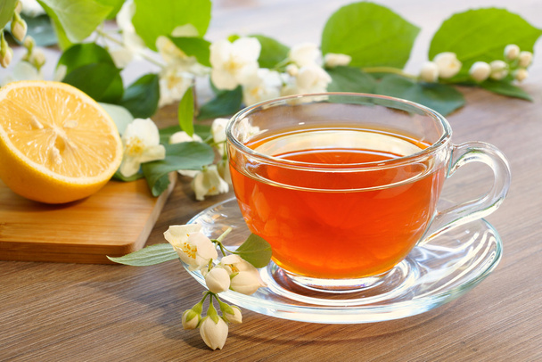 Tè con limone e rami di un gelsomino fiorente
 - Foto, immagini