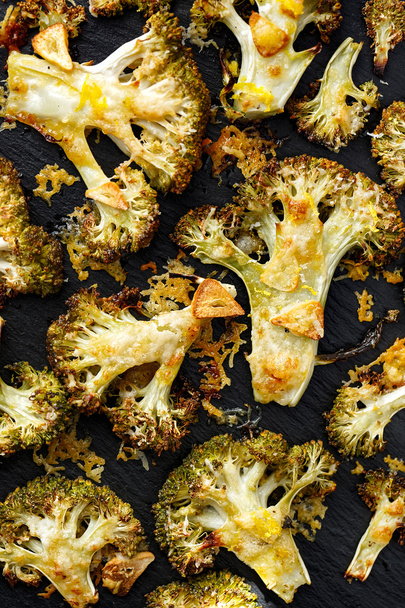 Geroosterde broccoli met toevoeging knoflook, olijfolie en citroenschil, bestrooid met Parmezaanse kaas - Foto, afbeelding