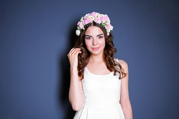 Beautiful young woman with flowers on head - Foto, afbeelding