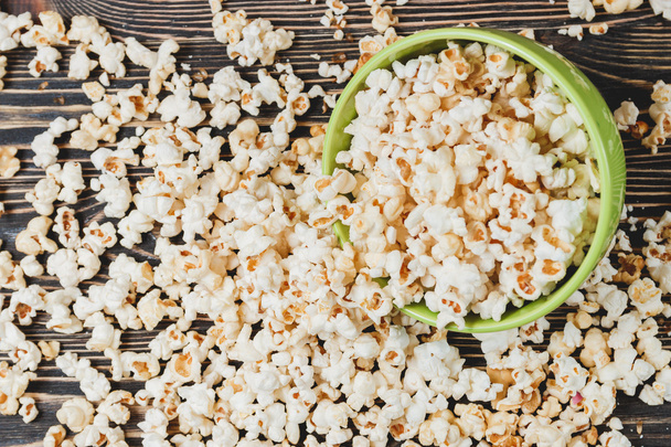 Sweet Caramel Popcorn in Green Bowl on Wooden Background - Fotó, kép