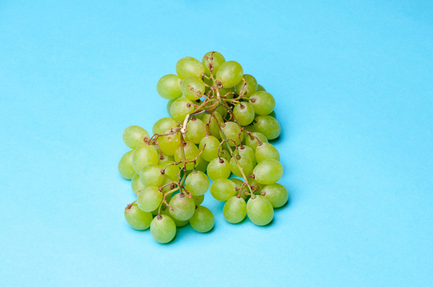 Uvas verdes sobre um fundo azul
 - Foto, Imagem