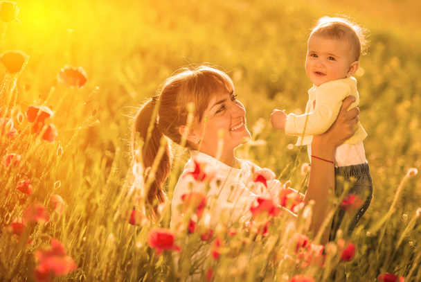 Mother and daughter with red poppies - 写真・画像