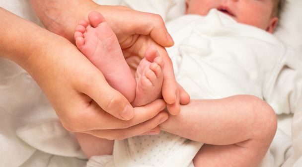 Baba lábát. Lábak újszülött testvére kezét - Fotó, kép