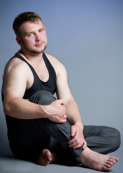 Young muscular man on dark background - Foto, Imagen