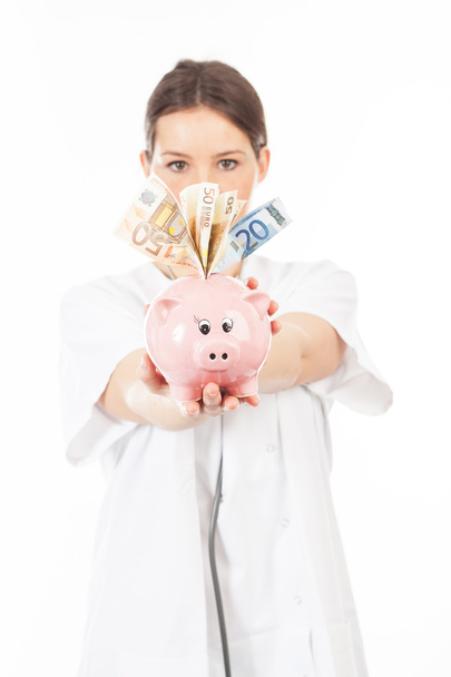 A woman shows a piggy bank  - Foto, imagen