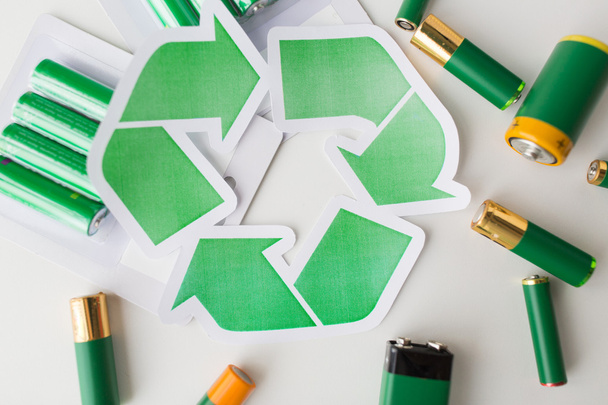 close up of batteries and green recycling symbol - Foto, Imagem