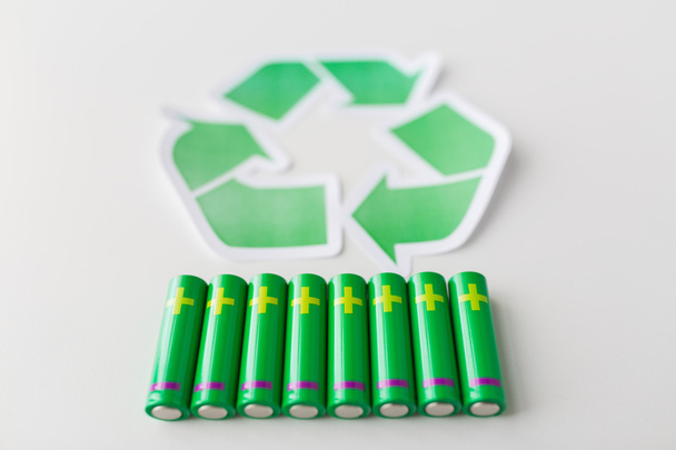 close up of batteries and green recycling symbol - Foto, Bild