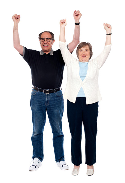Excited aged couple posing with raised arms - Foto, afbeelding