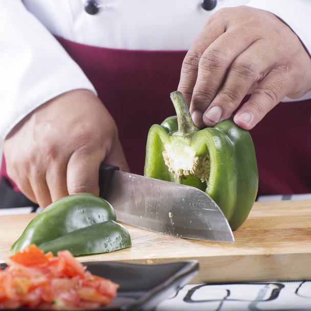 Σεφ κοπή πράσινη πιπεριά καμπάνα με μαχαίρι πριν από το μαγείρεμα  - Φωτογραφία, εικόνα