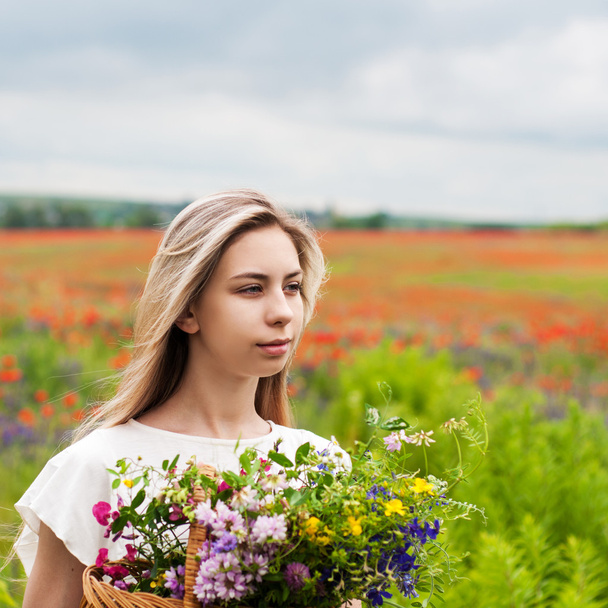 Hermosa chica rubia con flores silvestres
 - Foto, Imagen