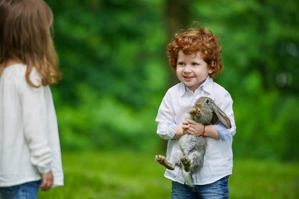niño y niña jugando con conejo
 - Foto, imagen