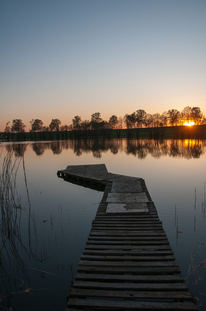 Деревянная пристань на озере под закатом
 - Фото, изображение