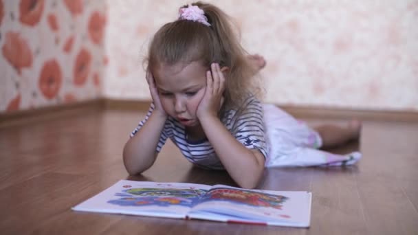 olvasó egy könyv feküdt a padlón miközben kislány - Felvétel, videó