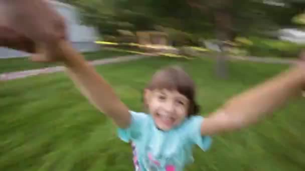 Νεαρό κορίτσι, γυρίζοντας γύρω στα χέρια τους γονείς, παιδί χαμογελά σε κάμερα - Πλάνα, βίντεο