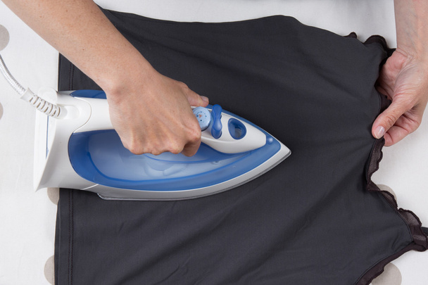 High angle view of woman ironing on ironing board - Foto, afbeelding