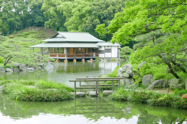Stone bridge with reflection and pavilion building in zen garden - Photo, Image