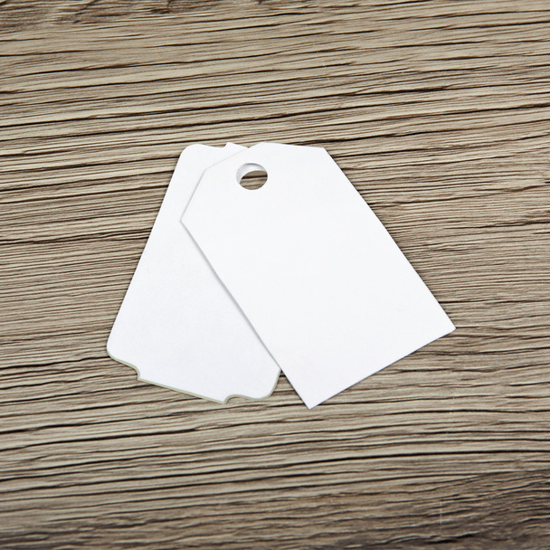 Close up of blank paper tags on wooden surface. - Фото, зображення