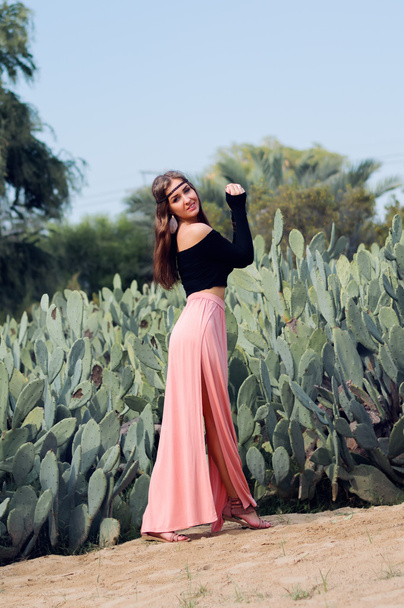Joven hippie mujer en falda rosa cerca del campo de los cactus
 - Foto, Imagen