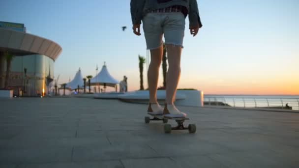 zblízka mužské nohy na longboard pohybující se nábřeží zpomalené - Záběry, video