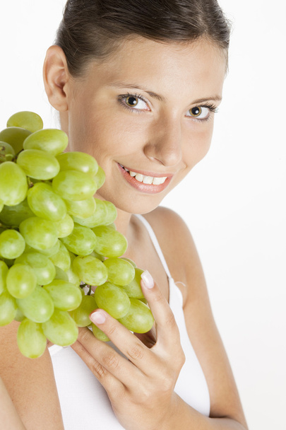 Portrait of young woman with grape - 写真・画像
