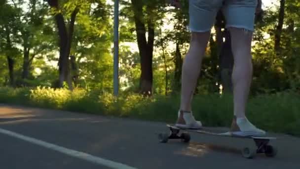 close up male legs on moving longboard in sun light slow motion - Footage, Video
