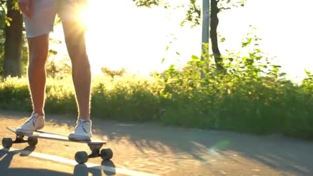 vicino gambe maschili in movimento longboard in luce solare rallentatore
 - Filmati, video