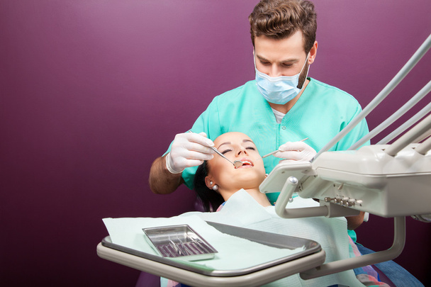 Homme dentiste examine la bouche de la femme sur la chaise du dentiste
 - Photo, image
