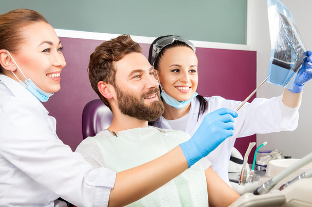 Стоматолог показує пацієнту рентгенівський знімок зубів
. - Фото, зображення