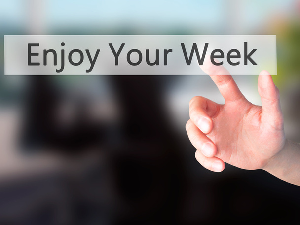 Enjoy Your Week - Hand pressing a button on blurred background c - Photo, Image