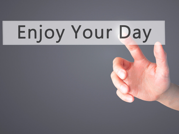 Enjoy Your Day - Hand pressing a button on blurred background co - Photo, Image