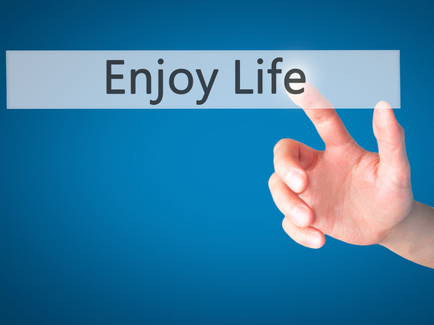 Enjoy Life - Hand pressing a button on blurred background concep - Фото, изображение