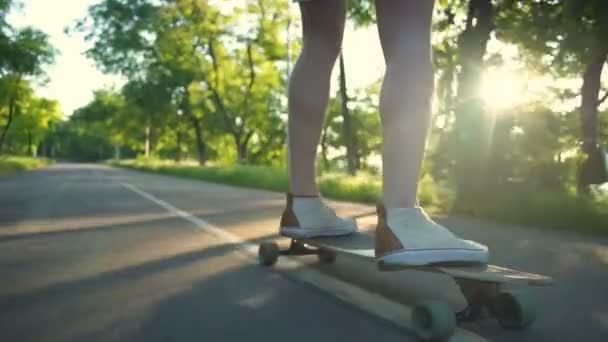cerca de los pies masculinos en longboard en movimiento en cámara lenta parque
 - Metraje, vídeo