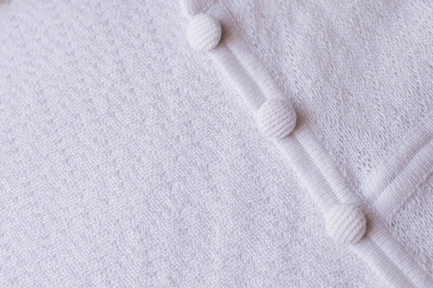 Pièce de robe tricotée blanche avec boutons, mise au point sélective
 - Photo, image