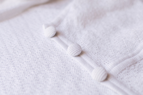 Кнопки на белом трикотажном платье, избирательный фокус
 - Фото, изображение