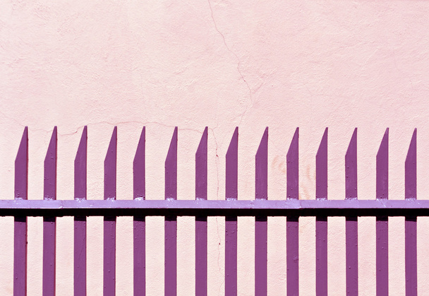 Roze metalen hek en gips muur.  - Foto, afbeelding
