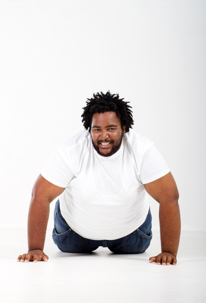 Funny fat african man lying on floor - Фото, зображення