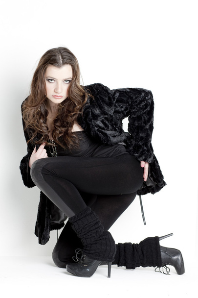 Kneeling young woman wearing black clothes - Zdjęcie, obraz