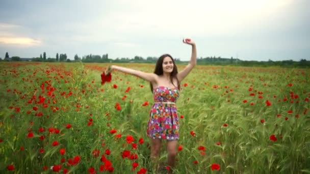 Happy mladá žena skákat nahoru a dolů v makovém poli zpomalené - Záběry, video