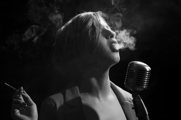 Woman with cigarette and retro microphone - Φωτογραφία, εικόνα