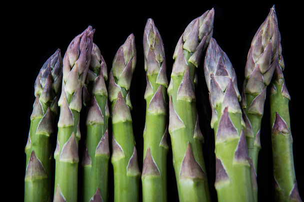 Raw asparagus on black background - Foto, afbeelding