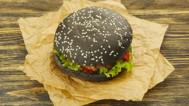 Ahşap masa üzerinde siyah burger - Video, Çekim