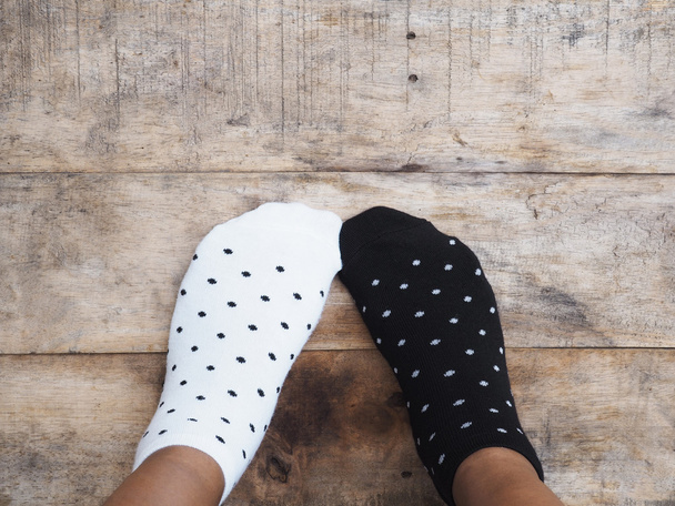 Füße tragen schwarz-weiße gepunktete Socken - Foto, Bild