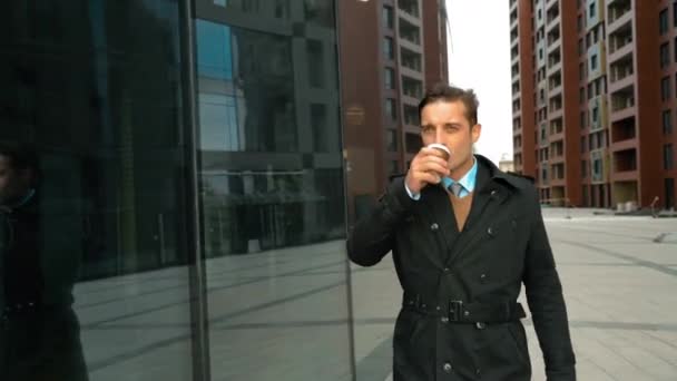 Businessman walking with coffee near business centre - Materiaali, video