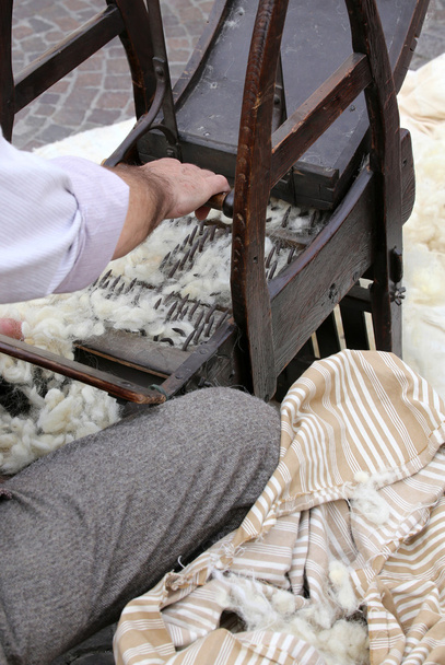 マットレスを作る木製の機械で梳綿ながら梳く - 写真・画像