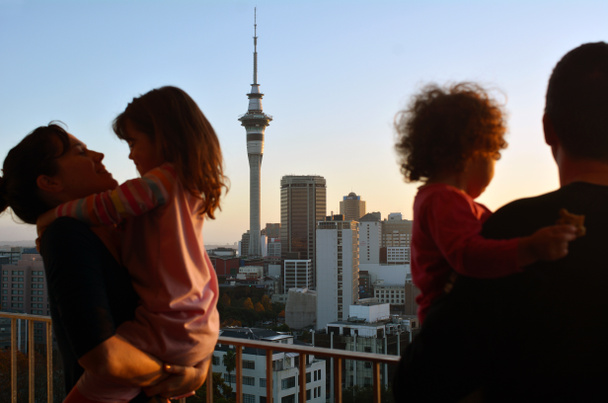 日の出都市のスカイラインを見て夫婦 2 人の子供と  - 写真・画像