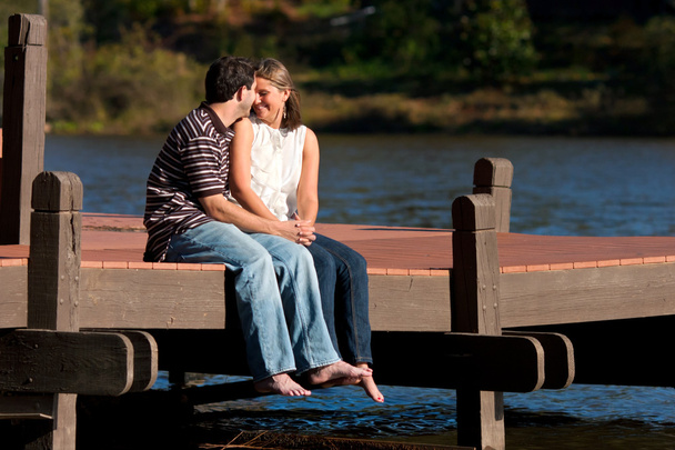 jovem casal no amor senta descalço no galo
 - Foto, Imagem
